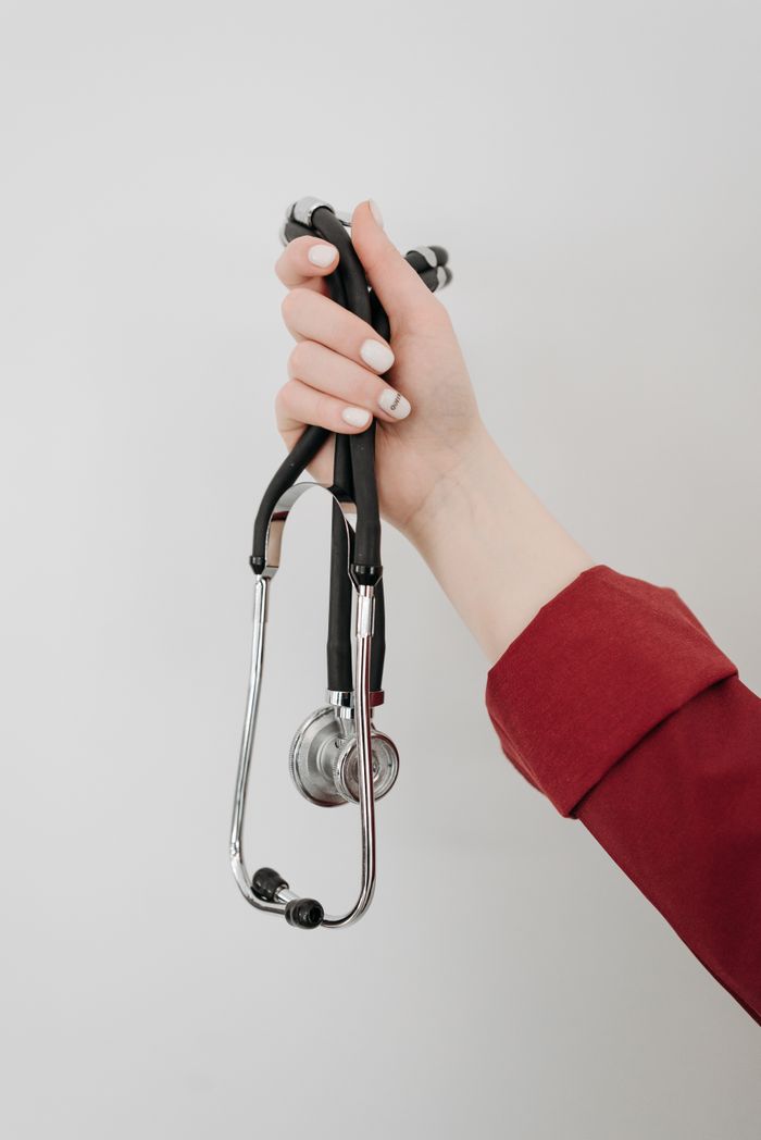 A person's hand holding a stethoscope, symbolizing healthcare and medical care.