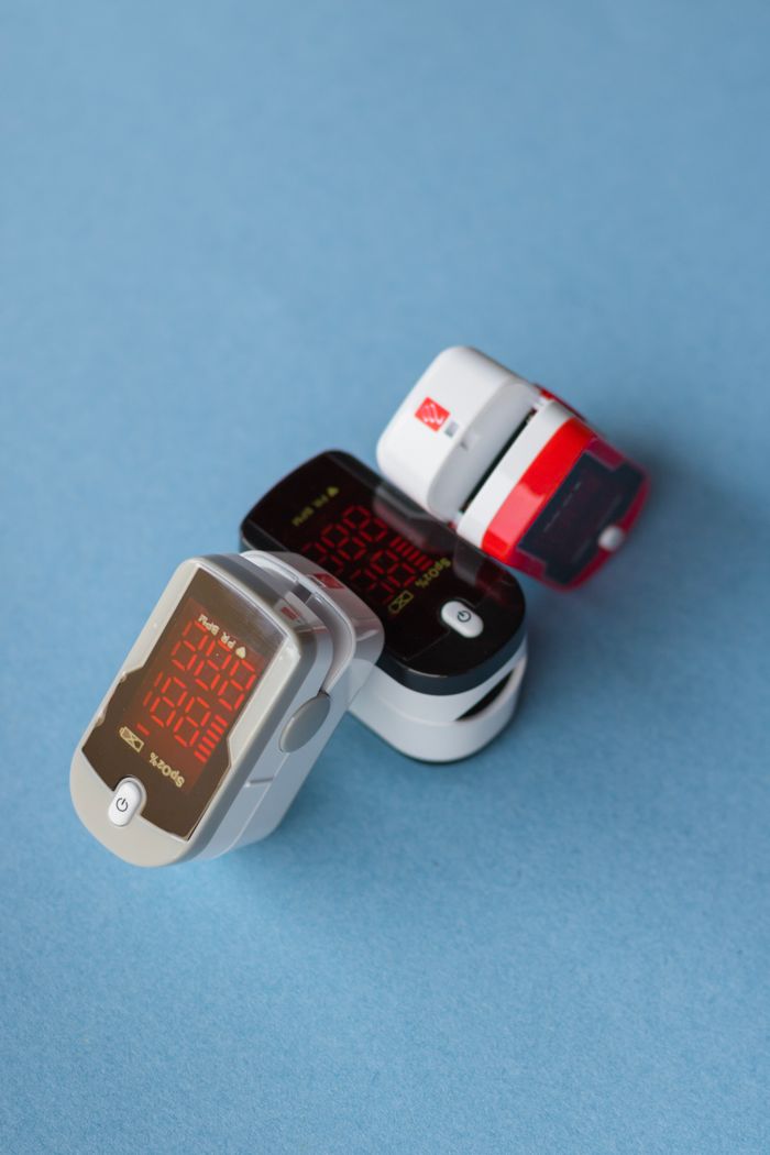 Detailed still life of pulse oximeters against a blue backdrop.