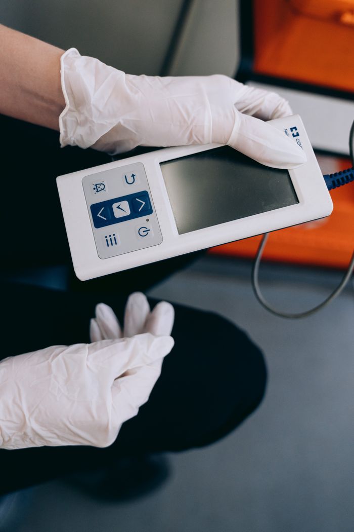 Close-up of paramedic hands with medical device in ambulance, emphasizing emergency healthcare.